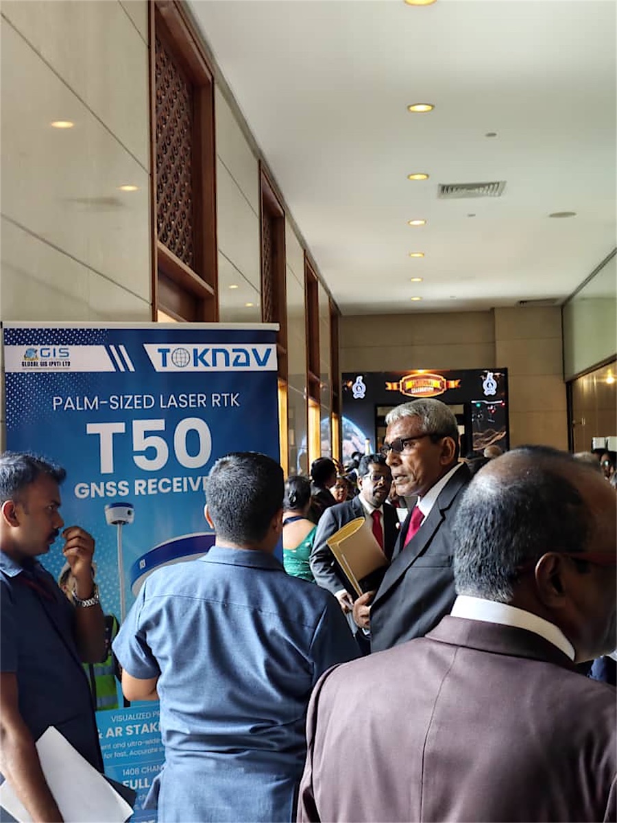 Surveying professionals gather around a TOKNAV T50 GNSS RTK display