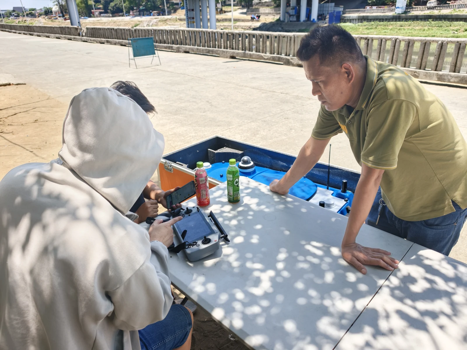 Team preparing a controller beside a TOKNAV TBoat in its transport case